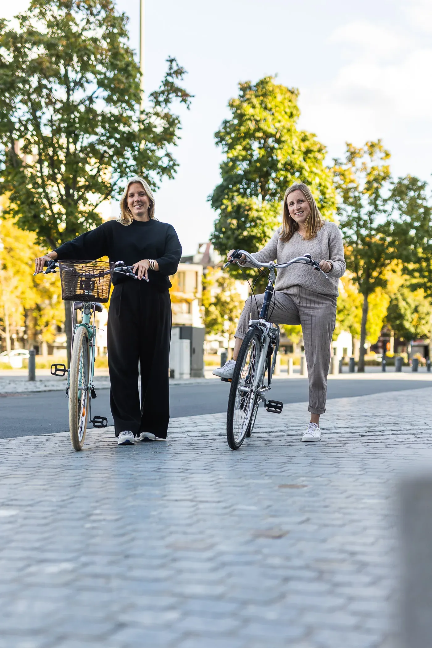 Twee Harmony-collega's met de fiets aan de hand.